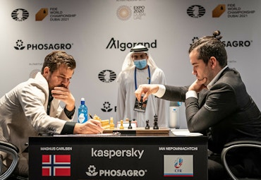 two man sitting playing chess board and pieces