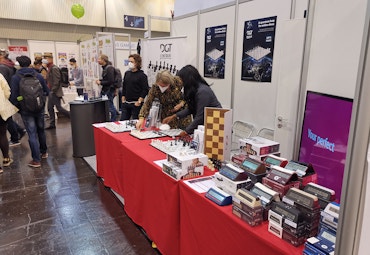 board game convention stand with chess clocks and people
